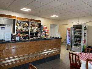 a bar in a restaurant with a counter and refrigerator at KM 80 Restaurant & Hotel in Mavrodolu