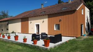 une maison avec des chaises et des plantes en pot devant elle dans l'établissement Jazz et Vacances, à Monlezun