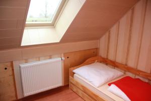 a small bed in a room with a window at GoWatt in Friedrichskoog