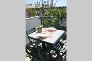 un tavolo e sedie seduti su un balcone di Appartamento delle Vele a Bellaria-Igea Marina
