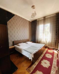 Un dormitorio con una cama grande y una ventana en Eka Guest House en Batumi