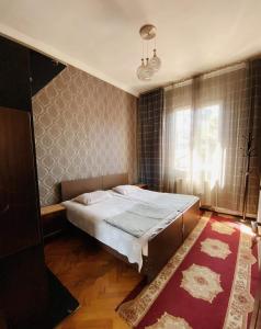una camera da letto con un letto grande e una finestra di Eka Guest House a Batumi