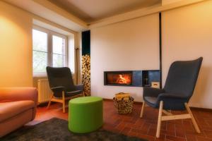 a living room with three chairs and a fireplace at Berghaus Falkenhorst in Kurort Altenberg