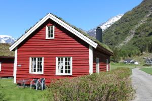 una casa rossa con tavoli e sedie di fronte di Trollbu Aabrekk gard a Briksdalsbre