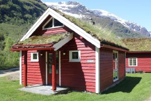 una casa rossa con erba sul tetto di Trollbu Aabrekk gard a Briksdalsbre