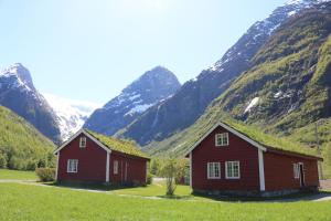 Deux granges rouges devant une montagne dans l'établissement Trollbu Aabrekk gard, à Briksdalsbre