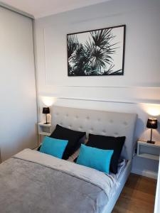 a bedroom with a large bed with blue pillows at Apartament Gdańsk in Gdańsk