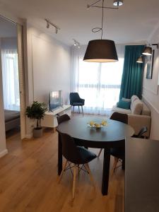 Apartament Gdańsk في غدانسك: غرفة معيشة مع طاولة وكراسي وغرفة معيشة
