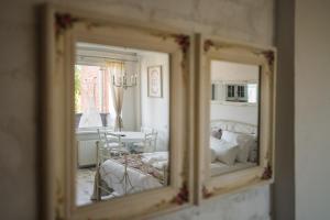 um espelho que reflecte um quarto com uma cama e uma mesa em Vintage Lounge studio by the sea in Liepaja em Liepāja