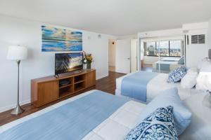 une chambre d'hôtel avec deux lits et une télévision à écran plat dans l'établissement Waikiki Penthouse @ The Monarch Hotel, à Honolulu
