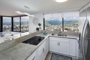 a kitchen with a sink and a view of a city at Waikiki Penthouse @ The Monarch Hotel in Honolulu