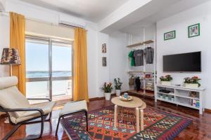 een woonkamer met een televisie en een tafel en stoelen bij Sea View Fairy Tale in Faro