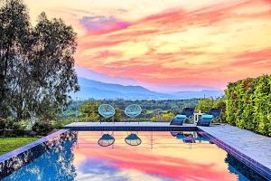 ゲオルギオポリスにあるCretan Mansion with Heated Swimming Poolの山々の景色を望むプール(椅子付)
