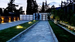 - un jardin avec des lumières sur l'herbe la nuit dans l'établissement Olivujoj Villajoj - Deluxe Villa with Detached Pool House, à Anavyssos