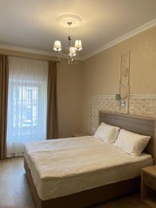 ein Schlafzimmer mit einem großen Bett und einem Kronleuchter in der Unterkunft Coffee Room in Odessa