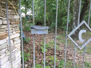 a gate with a bird house on it next to a stone wall at Cherokee Mountain log Cabins in Eureka Springs