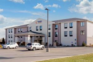 a hotel with two cars parked in a parking lot at Comfort Suites South Haven near I-96 in South Haven