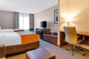 a hotel room with a bed and a desk with a computer at Comfort Suites South Haven near I-96 in South Haven