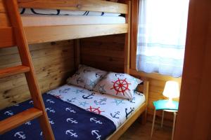 a small bunk bed in a room with a ladder at Domki letniskowe ZŁOTE PIASKI Ustka in Ustka