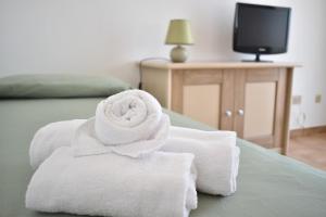 a pile of towels sitting on top of a bed at Hotel Residence Ampurias in Castelsardo