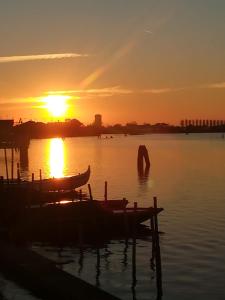 a sunset over a body of water with a boat at Casa Pianta in Cavallino-Treporti