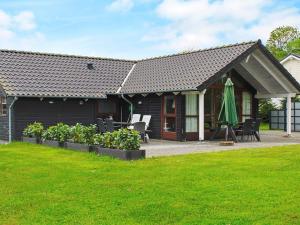 a house with a patio and a lawn at 8 person holiday home in Aabenraa in Loddenhøj