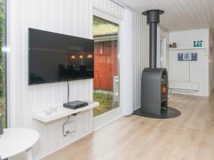 a living room with a wood stove in a house at 6 person holiday home in R m in Bolilmark