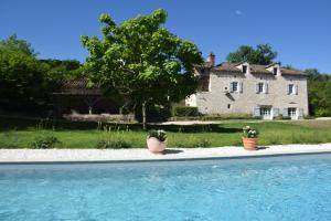 une maison avec deux plantes en pot à côté d'une piscine dans l'établissement Les Terrasses de La Serre, à Lascabanes