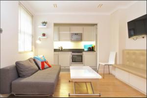 a living room with a couch and a table at Notting Hill Gardens Apartments in London