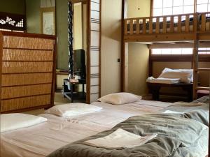 a bedroom with two bunk beds and a television at Guest House Enishi in Toyama