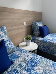una camera con due letti con cuscini blu e bianchi di Águeda Hostel & Friends ad Águeda