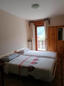 a bedroom with two beds and a window at Courma House in Courmayeur