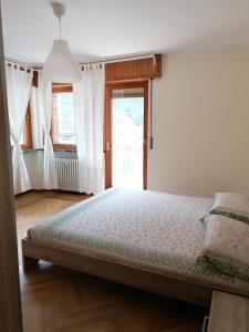 Un dormitorio con una cama grande y una ventana en Courma House, en Courmayeur