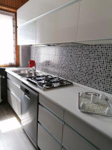 a kitchen with a stove and a white counter top at Courma House in Courmayeur