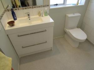 a bathroom with a white sink and a toilet at The Practice Fairway in Tauranga