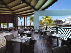 Très bel appartement avec Vue Mer, Accès Direct à la Plage et Piscine surveillée في سانت فرانسوا: مطعم على الشاطئ مع طاولات وكراسي