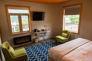 a bedroom with a bed and two chairs and a fireplace at Adventure Hotel in Nelson