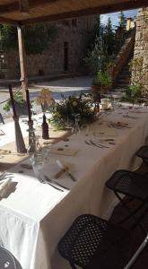 a long table with white tablecloths and glasses on it at Bed And Breakfast Belvedere in Suvereto