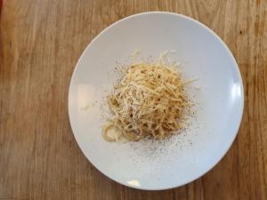 een wit bord pasta op een houten tafel bij Bed And Breakfast Belvedere in Suvereto