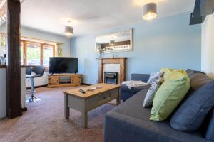 a living room with a blue couch and a table at The Windmill Cottage in Melton Mowbray