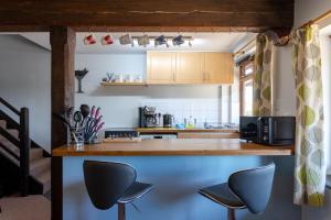 a kitchen with a counter and two chairs at The Windmill Cottage in Melton Mowbray