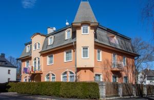 ein großes orangenes Haus mit grauem Dach in der Unterkunft Villa Anzio in Marienbad