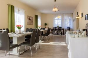 - une salle à manger avec des tables, des chaises et des fenêtres dans l'établissement Villa Anzio, à Mariánské Lázně