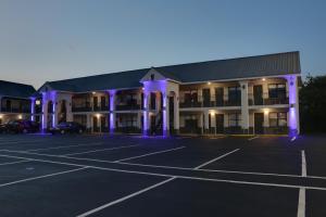 ein großes Gebäude mit lila Lichtern auf einem Parkplatz in der Unterkunft Travelodge by Wyndham Calhoun South I-75 in Calhoun