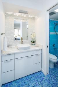 a white bathroom with a sink and a toilet at Waikiki Banyan Modern One Bedroom Free Parking in Honolulu