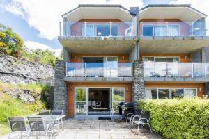 a house with a balcony and a patio at Lakeside Luxury with Spa in Queenstown