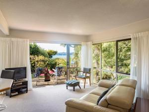 a living room with a couch and a large window at Craicor Boutique Apartments in Paihia