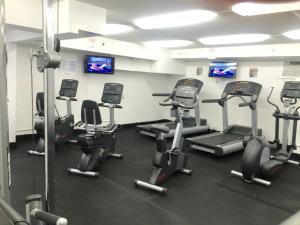 a gym with several cardio machines in a room at Modern Waikiki Sleek Studio in Honolulu