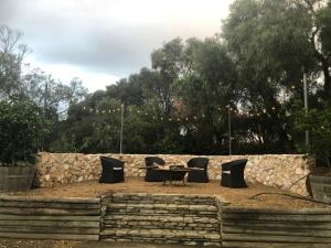 a table and chairs in front of a stone wall at Amande Bed and Breakfast in McLaren Vale