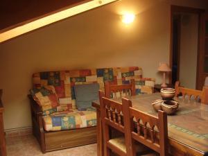 a dining room with a table and a couch at Casa Magí in Vilaller